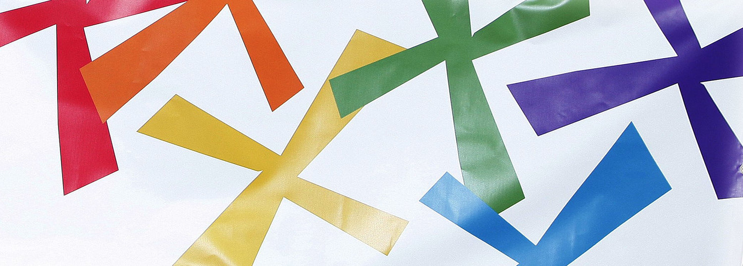 A fragment of a white banner with stylised saltires in rainbow colours.