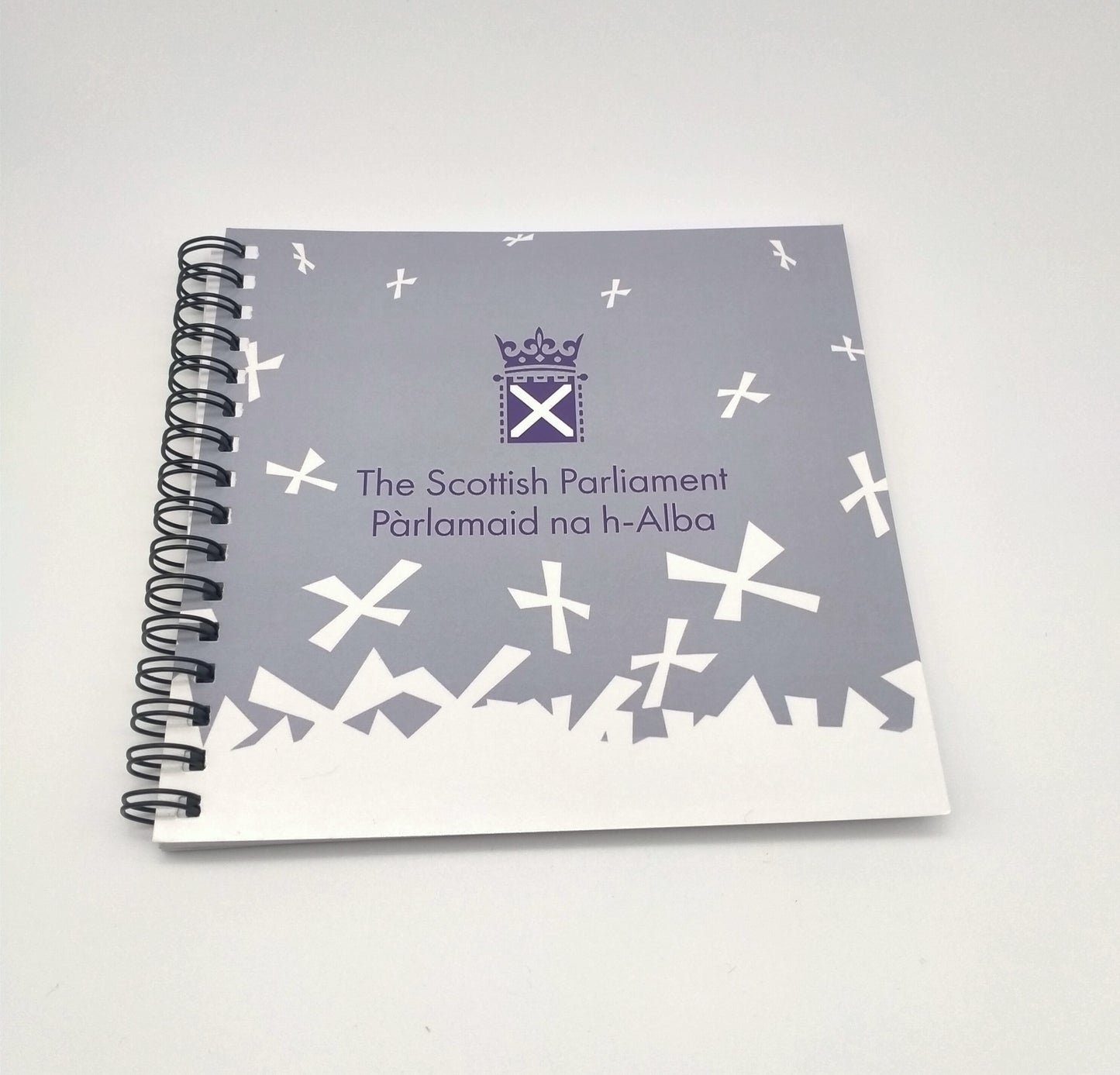 Spiral bound, square notebook with white Parliament symbol and saltires on grey background.