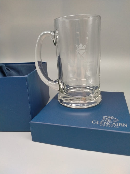 A crystal tankard engraved with the symbol of the Scottish Parlaimeent placed on a lid of its original blue box.