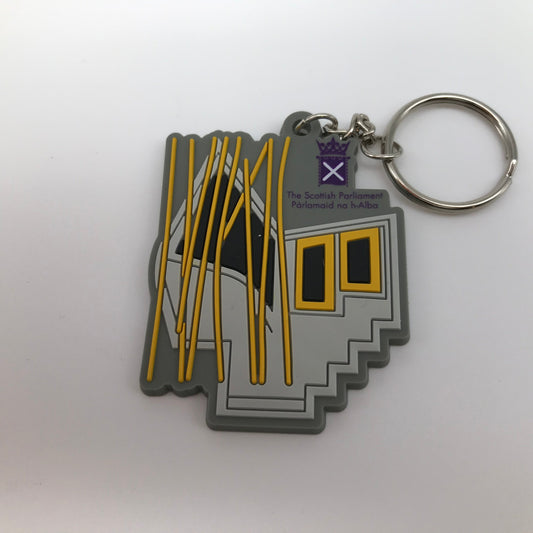 The shape of the MSP window on a grey base with black and gold. Purple Parliament symbol and silver key chain.