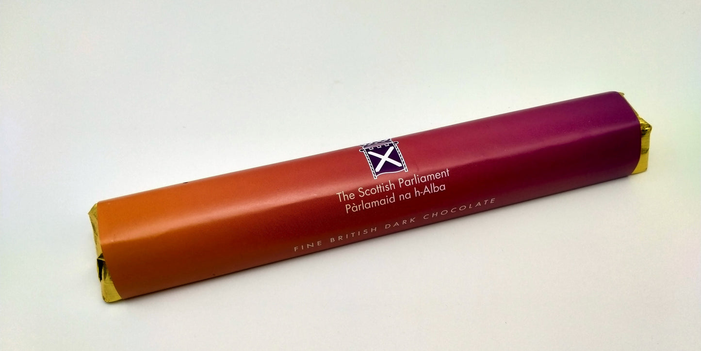 Rectangular chocolate bar with mauve fading to peach coloured wrapper printed with the Parliament symbol.