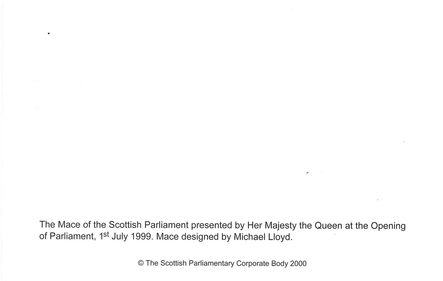Back of the card. White with description: The Mace of the Scottish Parliament presented by Her Majesty the Queen at the Opening of Parliament, 1st July 1999. Mace designed by Michael Lloyd. 