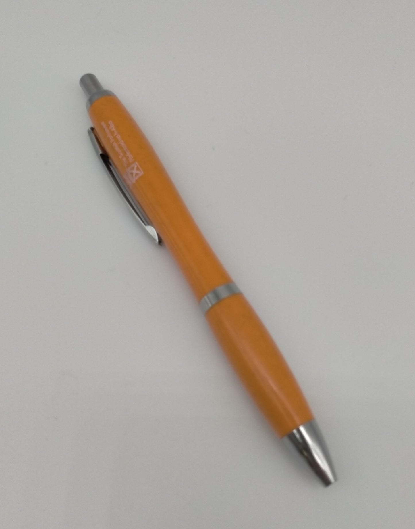 Orange pen decorated with the symbol of the Scottish Parliament with silver elements.