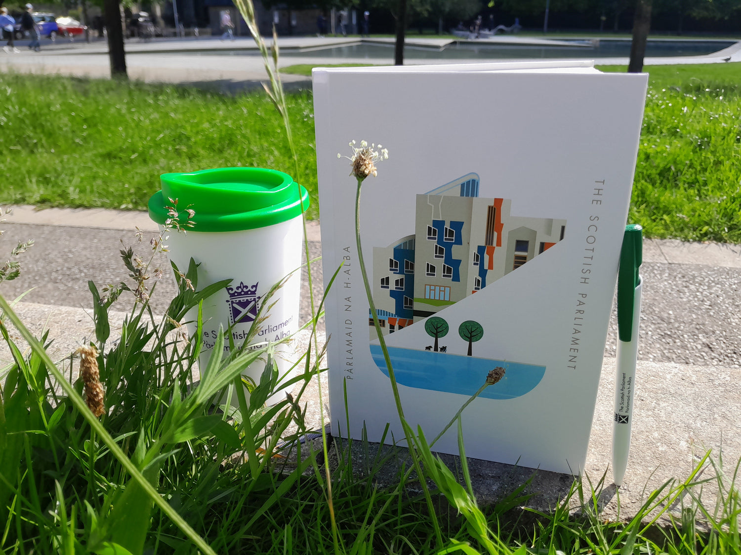 A notebook, a pen and a reusable cup 