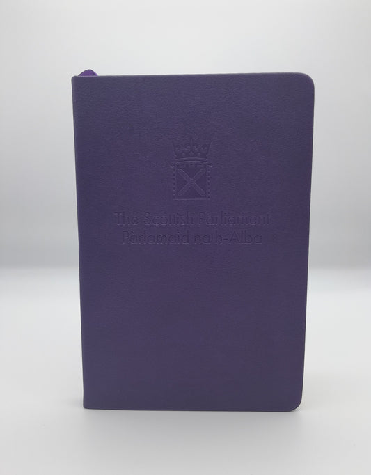 A purple notebook embossed with the symbol of the Scottish Parliament.