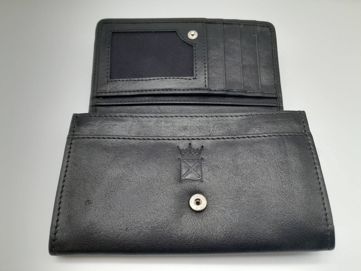 The purse open. Black leather embossed with the symbol of the Scottish Parliament.
