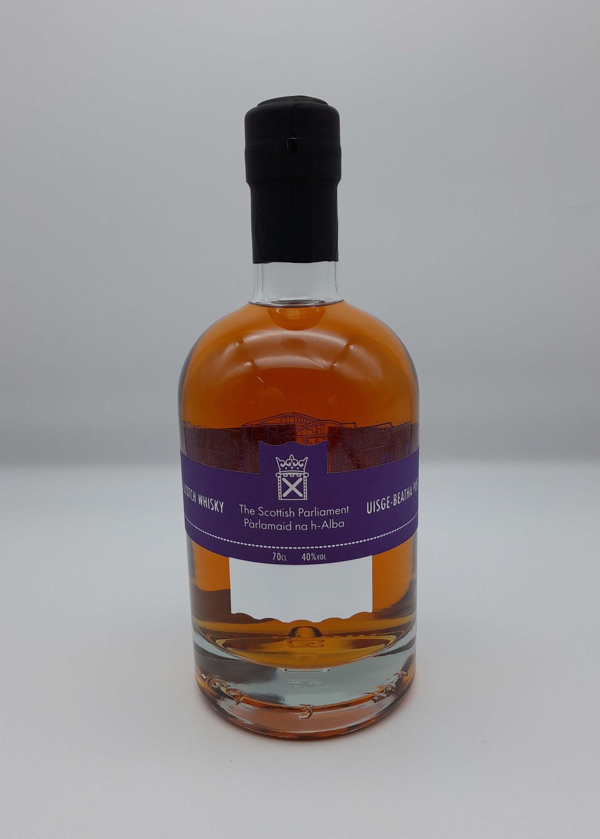 A bottle of blended whisky with a purple label printed with the symbol of the Scottish Parliament.