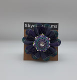 Green and purple tartan flower shaped brooch with decorative beads.