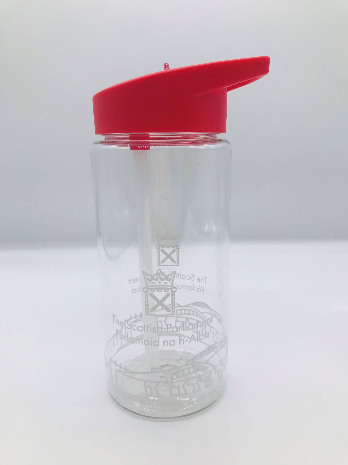 A clear plastic bottle with internal straw. it has the Scottish Parliament logo and outline of the parliament building painted around the circumference of the bottle. Its lid is red