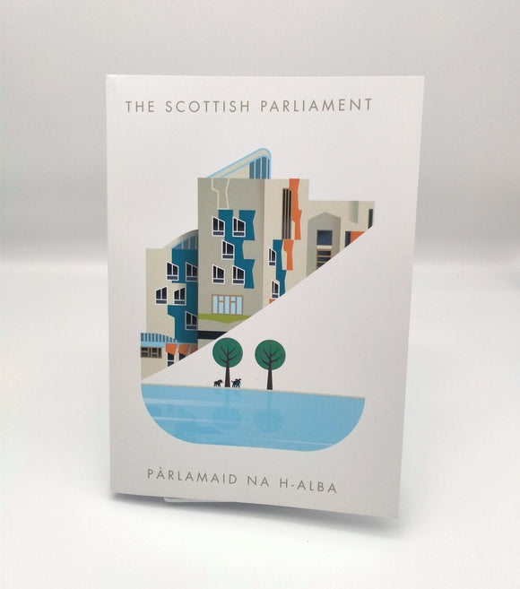 White paperback notebook printed with an image of a part of the Scottish Parliament building. A contemporary design features some architectural details of the building, a pond and trees.  Writing The Scottish Parlaiment in English and Gaelic. 