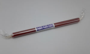 A red stick of rock in a plastic wrapping with a white and blue label.