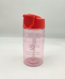 Transparent bottle tinted red and decorated with the symbol of the Scottish Parliament. Lid is red with a transparent pop-up spout.