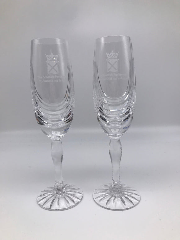 A pair of cut glass, crystal flute glasses engraved with the symbol of the Scottish Parliament,
