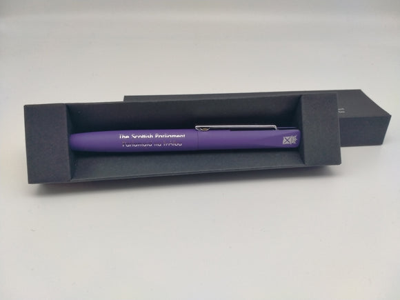 A purple pen with the symbol of the Scottish Parliament silver, in a black box.