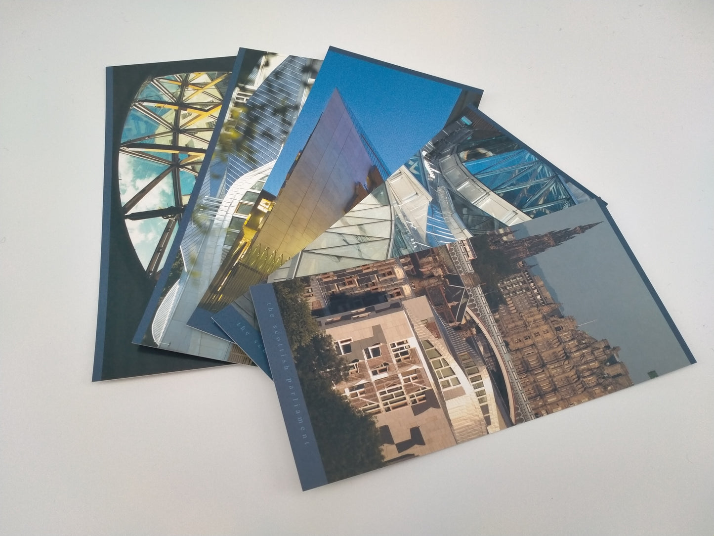 A selection of five postcards with images of the Scottish Parliament building.
