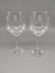 A pair of long-stem crystal goblets with a cut glass design and decorated with the symbol of the Scottish Parliament.