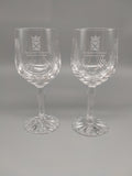 A pair of long-stem crystal goblets with a cut glass design and decorated with the symbol of the Scottish Parliament.