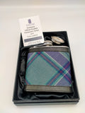 A hip flask covered with the official Scottish Parliament tartan fabric. In a black box.