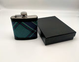 The hip flask standing next to its black box.
