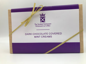 A rectangular box with white and purple label and golden ribbon.