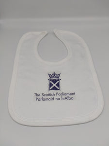 white baby's bib with the symbol of the Parliament printed in purple.