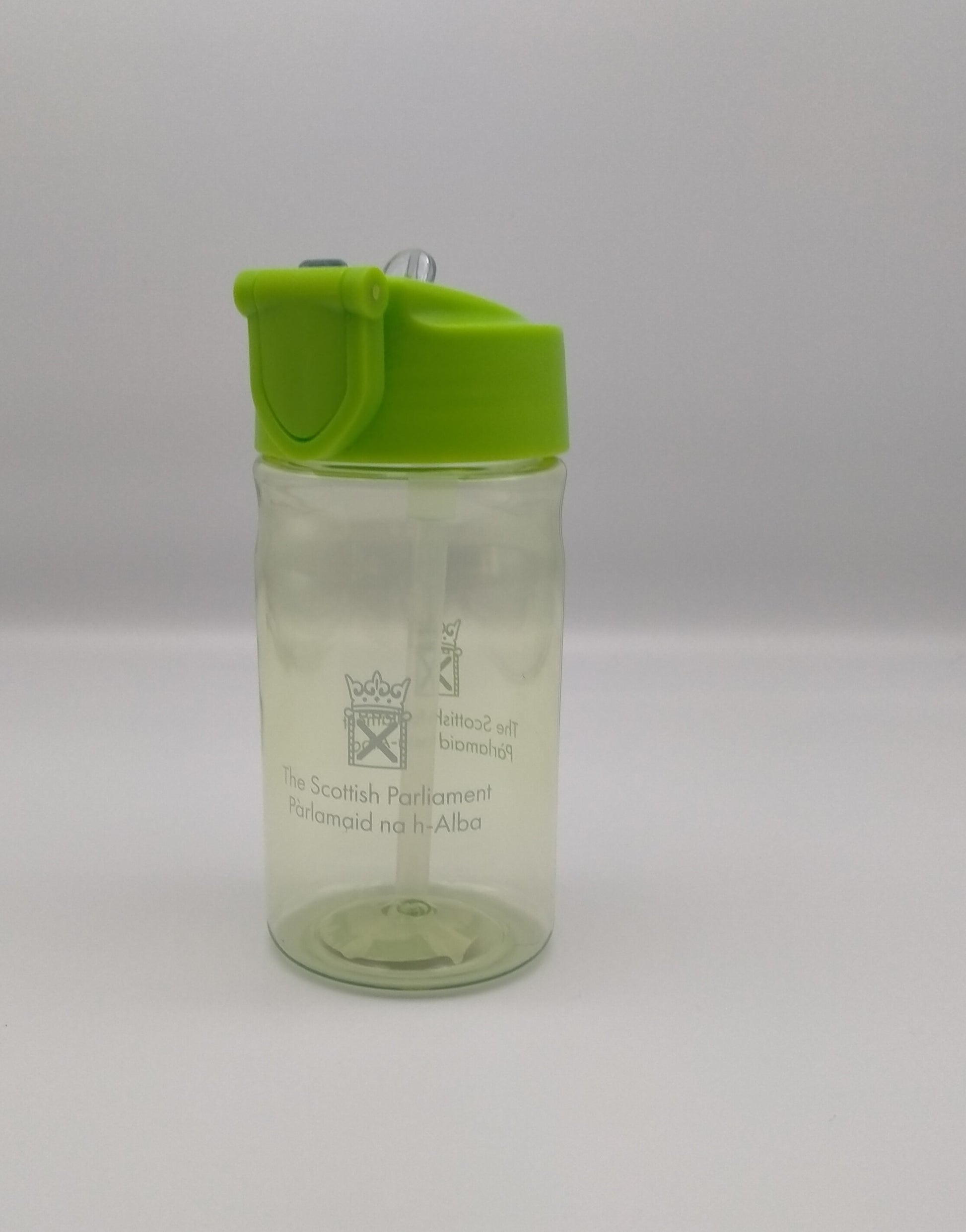 Transparent bottle tinted green and decorated with the symbol of the Scottish Parliament. Lid is light green with a transparent pop-up spout. 