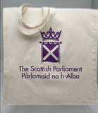 Square bag. Natural cotton colour featuring the parliament symbol printed in purple. Long handles.