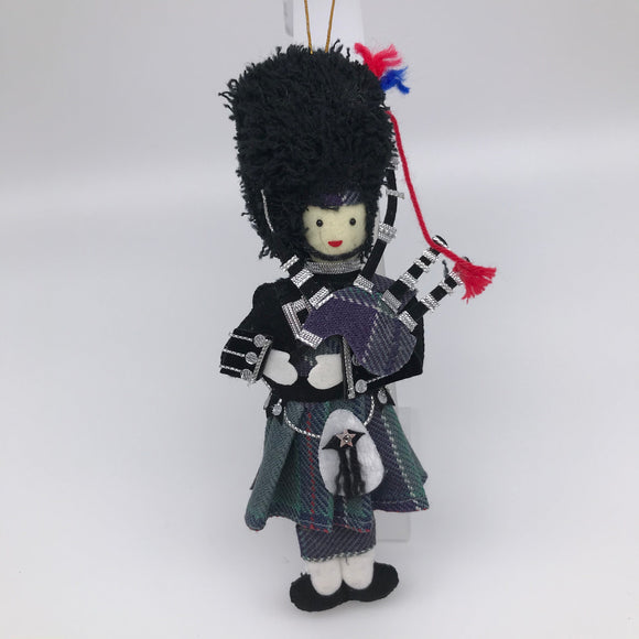 Piper in full Highland dress with tartan kilt and bagpipes. Wearing a black 