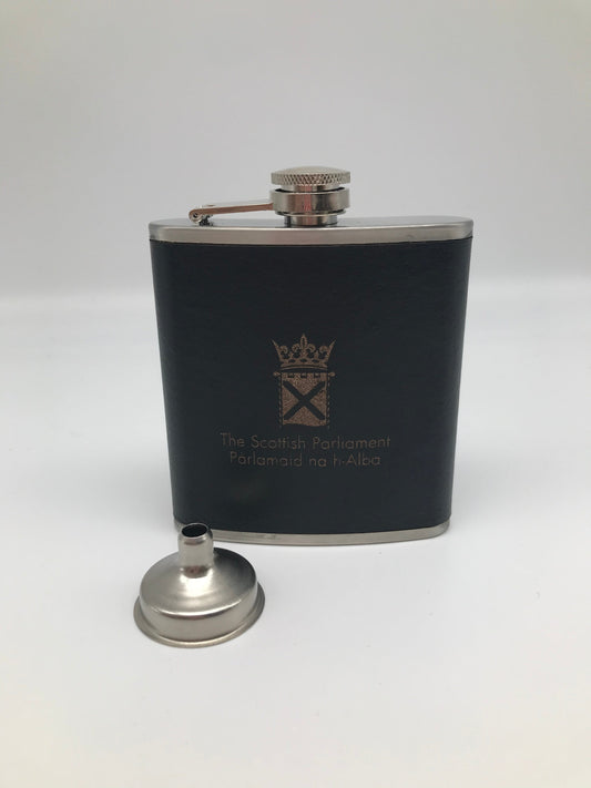 Silver coloured hip flask bound with dark brown leather engraved with the Parliament symbol. Stainless steel funnel.