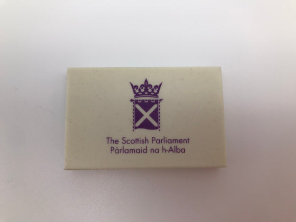 A rectangular white eraser with the symbol of the Parliament printed in purple.