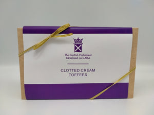 A rectangular box with white and purple label and golden ribbon.